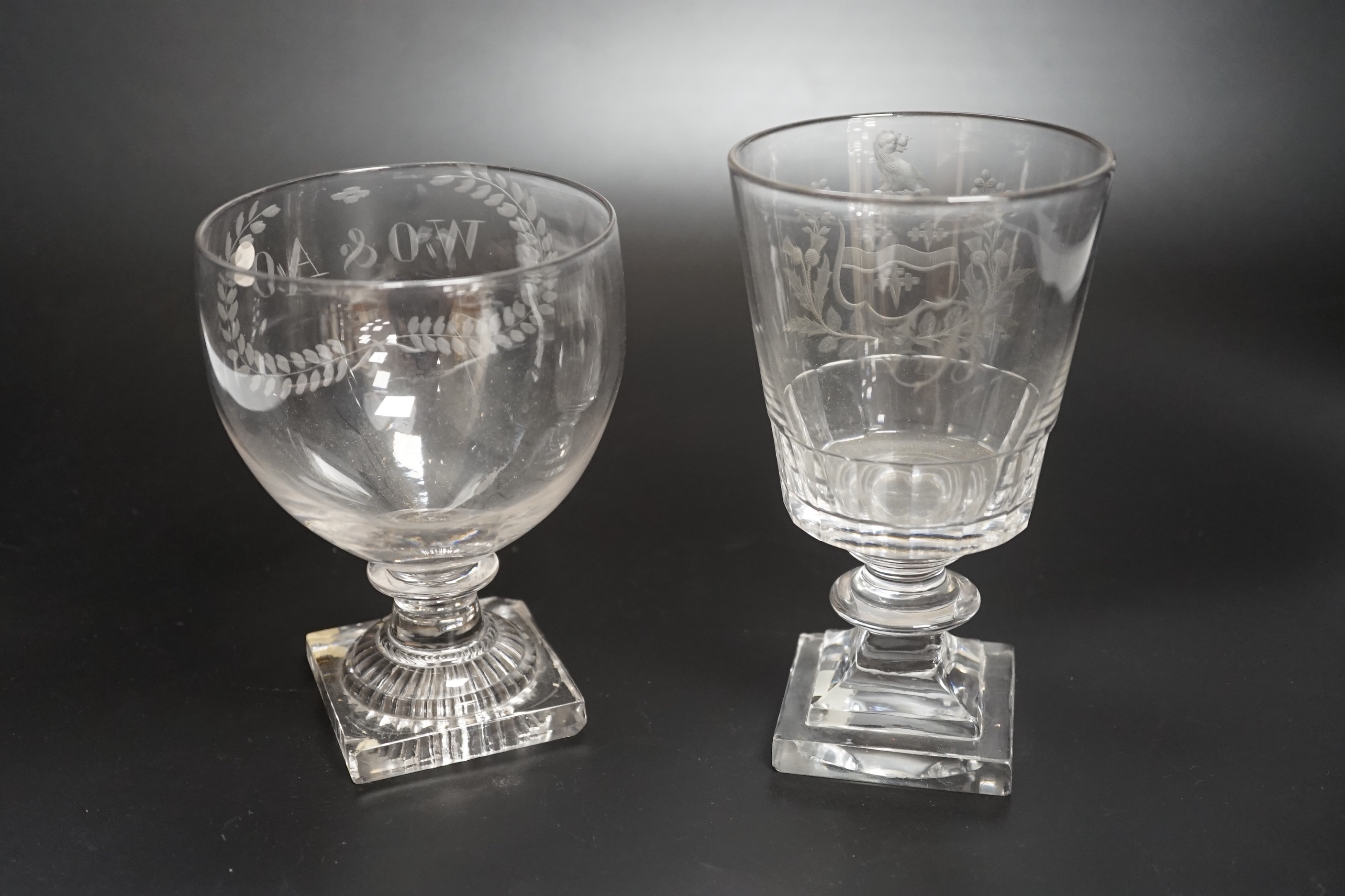 Two rummer style 18th century square-based goblets, both with etched designs, one a coat of arms, both stems with flattened knobs and cut glass square bases, one with ‘lemon squeezer’ pontil, highest 15.5cm